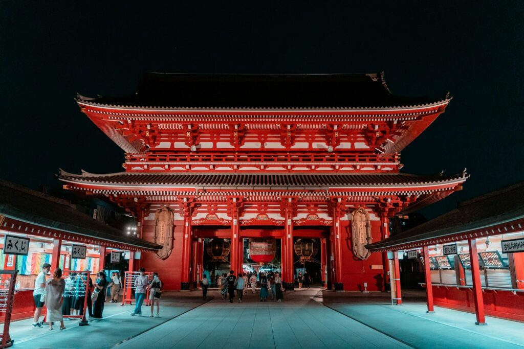 a red asian building with a black roof